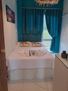 a bedroom with a bed with blue walls and a window at MANI HOLIDAYS Rooms in Neo Itilo