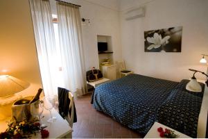 a bedroom with a bed and a table with a lamp at Hotel Corallo in Pomonte