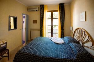 a bedroom with a blue bed in front of a window at Hotel Corallo in Pomonte