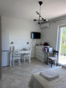 a living room with a table and a kitchen at Apartment Zekija in Barbat na Rabu