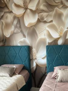 a bedroom with two beds and a wall with flowers at Damisa Lux Stan in Tivat +40 photos