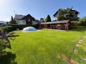 a large yard with a tent in front of a house at Penzion V Kolonce in Strážné
