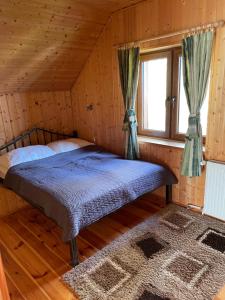 a bed in a wooden room with a window at Domki Florentyna Szklarska Poręba-Wojcieszyce in Wojcieszyce +109 photos
