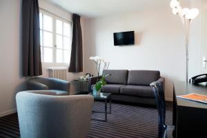 a living room with a couch and a table at Le Germinal in Cesson-Sévigné
