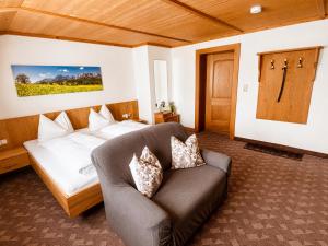 a hotel room with a bed and a couch at Beim Talschuster in Scheffau am Wilden Kaiser