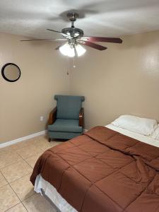 a bedroom with a ceiling fan and a chair at A cozy room with double bed in semi shared Flat in Wallisellen