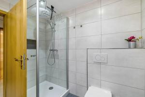 a white bathroom with a shower and a toilet at Leicht in Münsingen +21 photos
