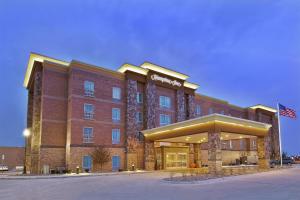 a large brick hotel with an american flag in front of it at Hampton Inn by Hilton West Bloomfield Novi in Farmington Hills
