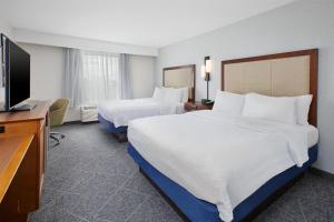a hotel room with two beds and a flat screen tv at Hampton Inn by Hilton West Bloomfield Novi in Farmington Hills +27 photos