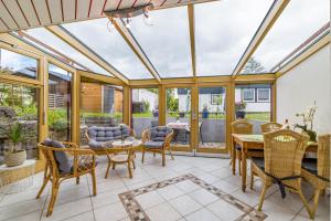 an orangery with a conservatory with a table and chairs at Leicht in Münsingen