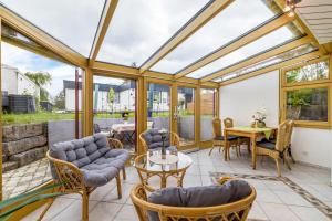a conservatory with a table and chairs at Leicht in Münsingen