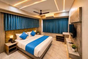 a hotel room with a bed and a television at Hotel Apollo Sp Ring Road Odhav Ahemdabad in Ahmedabad +27 photos