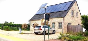 a car parked in front of a house with a solar roof at Julie's Place in Westerlo