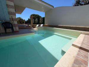 a swimming pool with blue water in a house at Villa Aurea in Avola