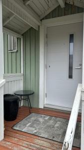 a porch with a table and a white door at Peaceful studio with sauna in Liperi