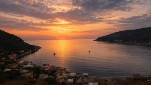 a sunset over a body of water with boats in it at MANI HOLIDAYS Rooms in Neo Itilo