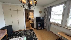 a living room with a large window and a television at Peaceful studio with sauna in Liperi