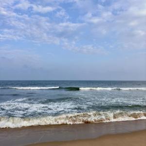 a beach with waves in the ocean with a sky at Koovathur Ecr beach house in Kūvattūr
