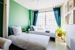 two beds in a room with a window at 2 ch, climatisé, parking, localisation premium in Lyon