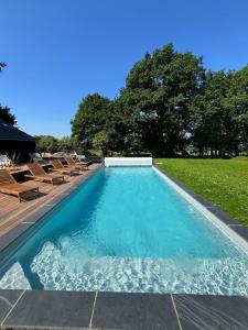 a swimming pool with chairs in a yard at L'échappée in Neulliac
