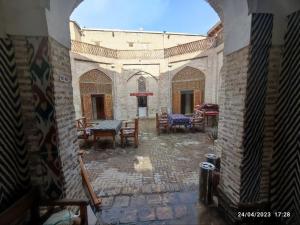 a courtyard with tables and chairs in a building at Caravan Sarai XV century Mextar Ambar old town in Bukhara +70 photos