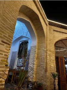 a building with an archway with a painting on it at Caravan Sarai XV century Mextar Ambar old town in Bukhara