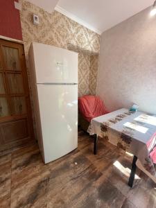 a kitchen with a white refrigerator and a table at Full moon in Yerevan