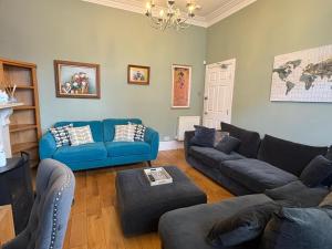 a living room with blue couches and a blue couch at Abbey GH All Rooms En-Suite in Redcar