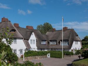 a large white house with a thatched roof at Ferienhaus Klenterdeel in Keitum