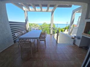 a table and chairs on the balcony of a house at Vlad's Apartments in Larisa