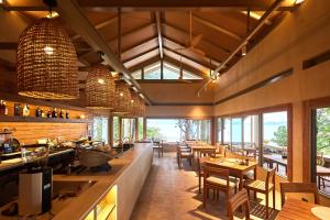 a restaurant with tables and chairs and windows at Amber Yao Noi in Ko Yao Noi