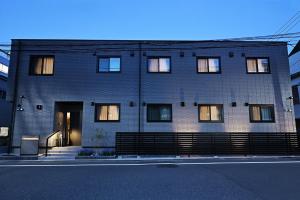 a large brick building with windows on a street at WANOKAEDE HOTEL New Wing in Tokyo