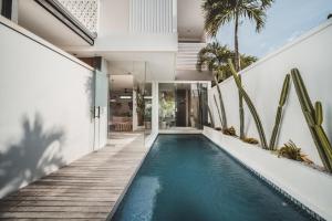an infinity pool in the backyard of a house at Eight Palms Villa Seminyak by Ini Vie Hospitality in Seminyak