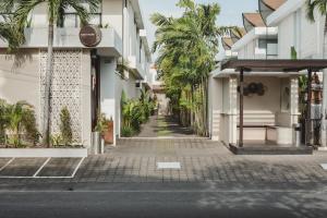 an empty street with buildings and palm trees at Eight Palms Villa Seminyak by Ini Vie Hospitality in Seminyak