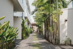 an alley between two buildings with palm trees at Eight Palms Villa Seminyak by Ini Vie Hospitality in Seminyak