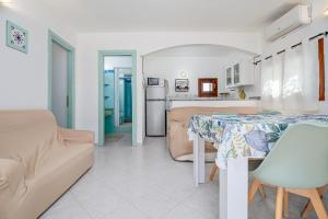 a living room and kitchen with a table and a couch at Villa Rosa in Olbia