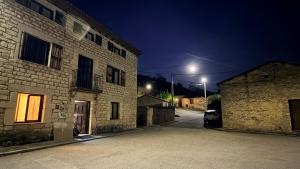 an alley at night with a car parked next to a building at Los Quejigares in Terradillos de Sedano