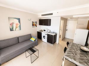 a living room with a couch and a kitchen at Azure apartments Haifa in Haifa