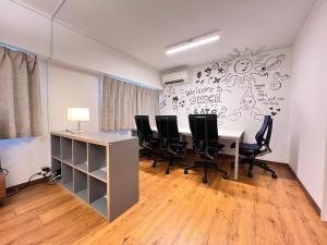 an office with a table and chairs and a wall at 北浜 港近くの個室ステイ in Takamatsu
