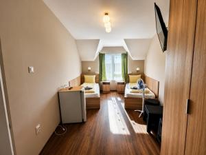 a room with two beds and a desk in it at Hotel Doina 1 Tășnad in Tăşnad