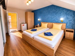 a bedroom with a large bed with blue walls at Hotel Doina 1 Tășnad in Tăşnad
