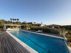 a swimming pool in a house with a wooden deck at Casa Poupa in Lagoa