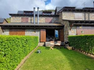 a house with a yard with a chair in front of it at Casa Adosada en Alp Jardin y Wifi in Alp