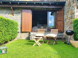 two chairs and a table and a grill in the grass at Casa Adosada en Alp Jardin y Wifi in Alp