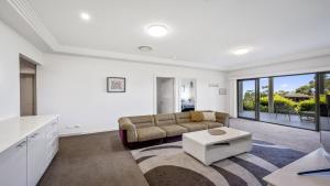 a living room with a couch and a table at 'Gone Coastal' by HolidayCo in Killcare +16 photos