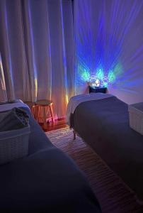 two beds in a room with blue and purple lights at Private big ROOM 20mins to Airport, 5mins to station in St Albans +22 photos
