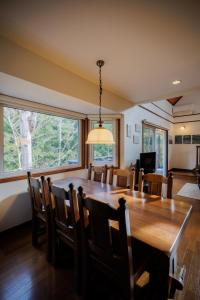 a dining room with a large wooden table and chairs at Villa Qualite ヴィラカリテ in Zao
