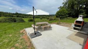 a picnic table with an umbrella and a grill at As Neveiras in Millerada +44 photos