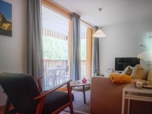 a living room with a couch and a table and a window at Saas Grund MiK Home in Saas-Grund