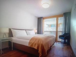 a bedroom with a large bed and a window at Saas Grund MiK Home in Saas-Grund